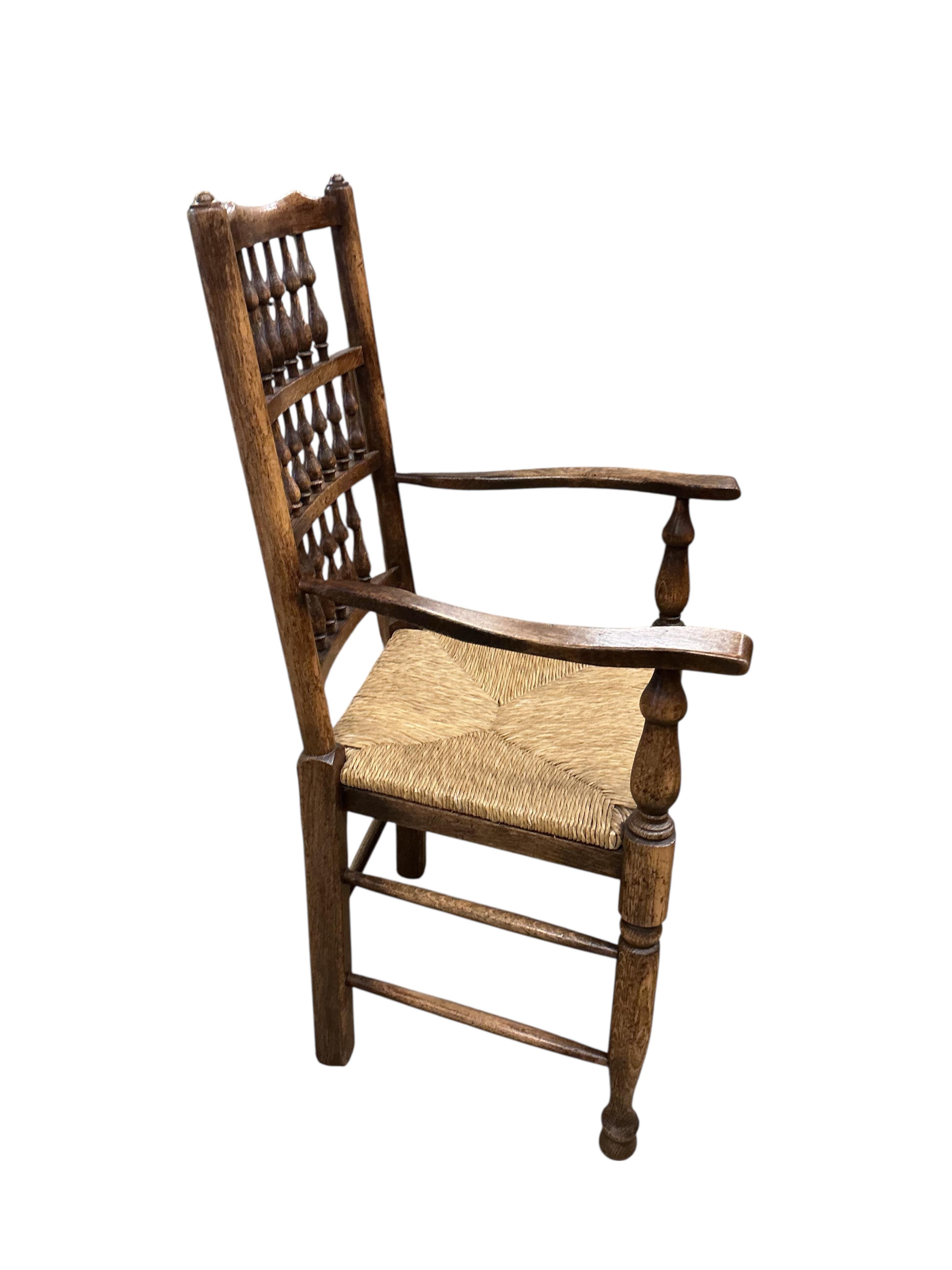 A set of ten Lancashire style ash and beech rush seat spindle back dining chairs, two with arms